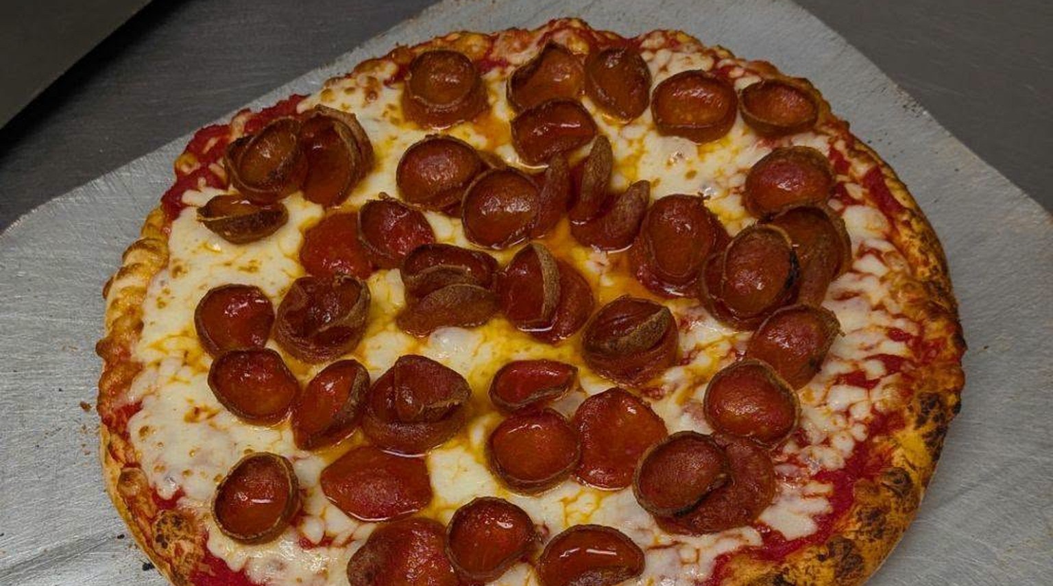 Fresh pepperoni pizza on a pizza peel at Gibeye’s Pizza